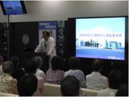 講演中の華岡院長と90インチモニター